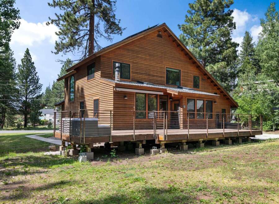 Experience rustic charm in this beautiful wooden home, featuring a spacious deck perfect for outdoor entertaining.