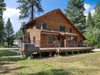 Experience rustic charm in this beautiful wooden home, featuring a spacious deck perfect for outdoor entertaining.