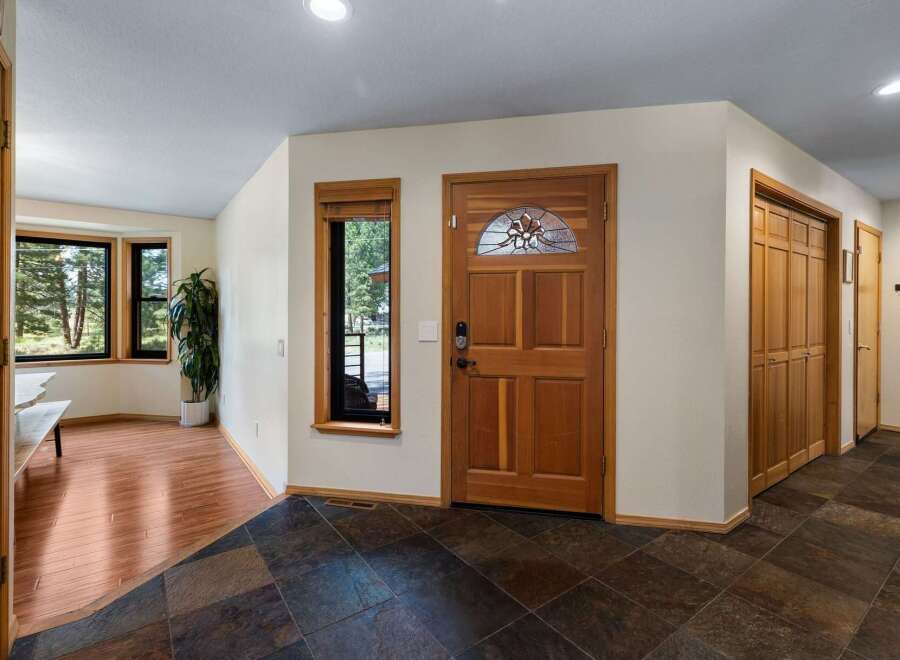 Step into a welcoming entryway featuring a beautiful wooden front door with stained glass accents.