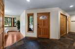 Step into a welcoming entryway featuring a beautiful wooden front door with stained glass accents.