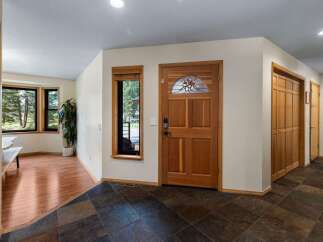 Step into a welcoming entryway featuring a beautiful wooden front door with stained glass accents.