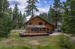 Experience rustic charm in this spacious wooden home, nestled amongst tall pine trees.