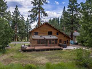 Experience rustic charm in this spacious wooden home, nestled amongst tall pine trees.