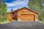 Experience rustic charm in this beautiful wooden cabin, featuring a spacious garage and a welcoming front porch.