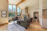 Experience rustic charm and modern comfort in this stunning living room, featuring a grand stone fireplace and soaring vaulted ceilings with exposed wooden beams.