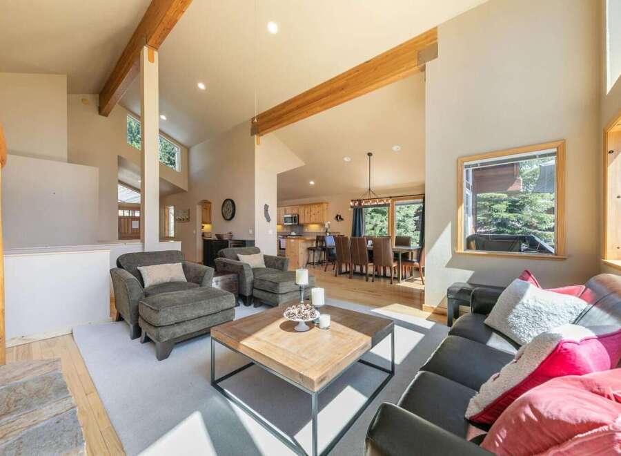 Experience the warmth of this inviting living space, featuring exposed wooden beams and a cozy stone fireplace.