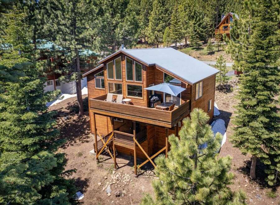Experience mountain living in this stunning wooden cabin nestled amongst tall pine trees.