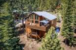Experience mountain living in this stunning wooden cabin nestled amongst tall pine trees.