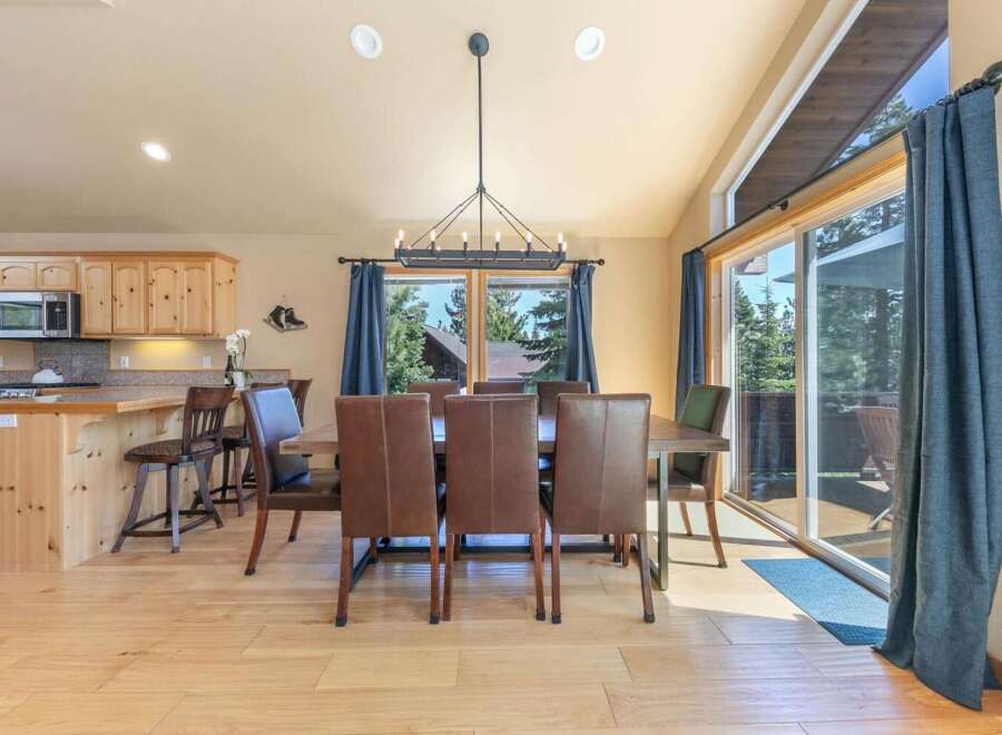 Experience comfortable dining in this spacious room featuring a large wooden table with plush leather chairs, perfect for family gatherings.