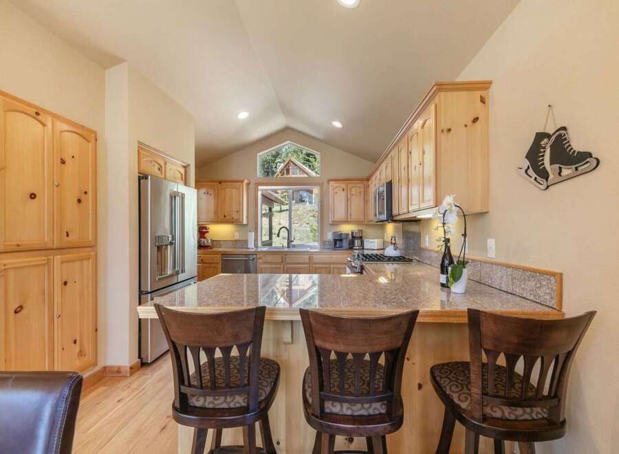 This spacious kitchen boasts beautiful light wood cabinetry and granite countertops, perfect for meal preparation and entertaining.