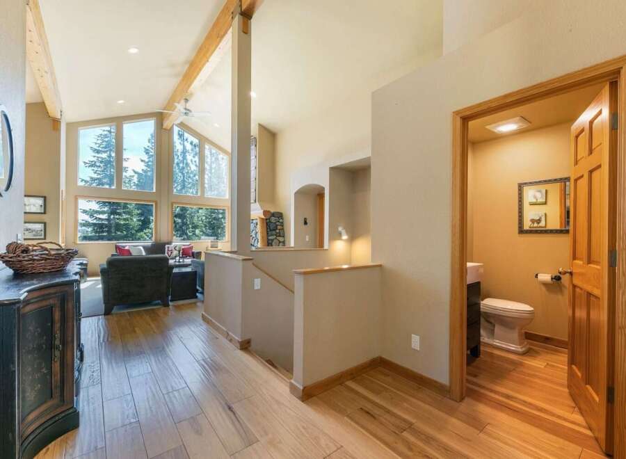 Experience breathtaking natural beauty from this stunning home, featuring expansive windows that frame panoramic views of lush evergreen trees.