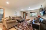 Step into this inviting living room, featuring a spacious sectional sofa perfect for gatherings and a large, ornate rug that adds a touch of elegance.