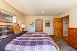 Experience cozy comfort in this inviting bedroom, featuring a plush plaid comforter and a warm wooden bed frame.