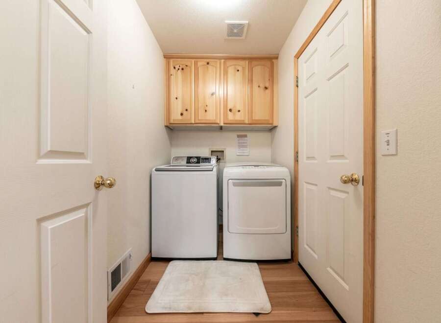 This laundry room features a stacked washer and dryer for efficient use of space.