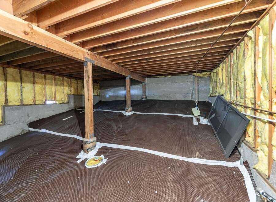 Explore the potential of this unfinished basement, featuring a robust subfloor drainage system and ample space for customization.