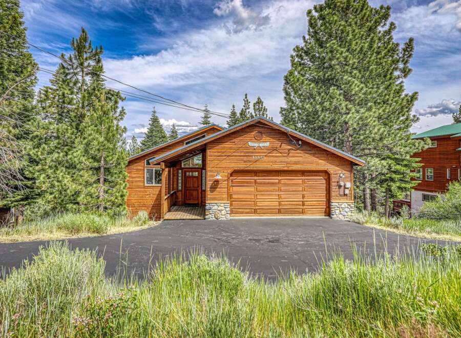 Nestled amidst tall pine trees, this charming wooden cabin offers a serene mountain retreat.