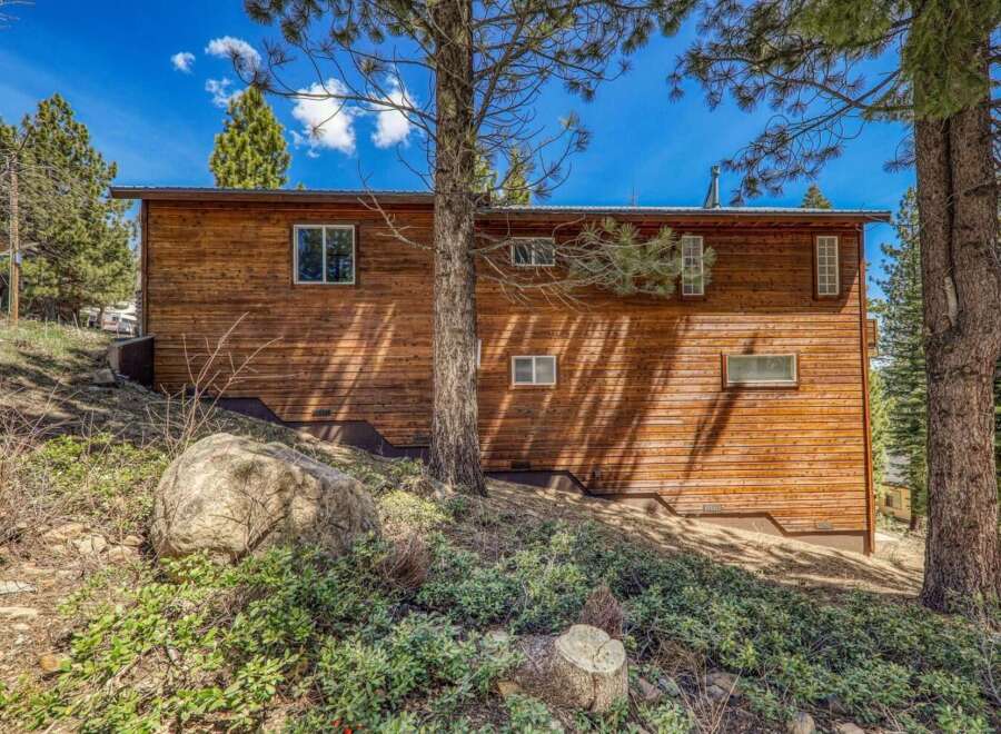 Nestled amongst tall pine trees, this charming wooden home offers a serene mountain retreat.