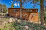 Nestled amongst tall pine trees, this charming wooden home offers a serene mountain retreat.