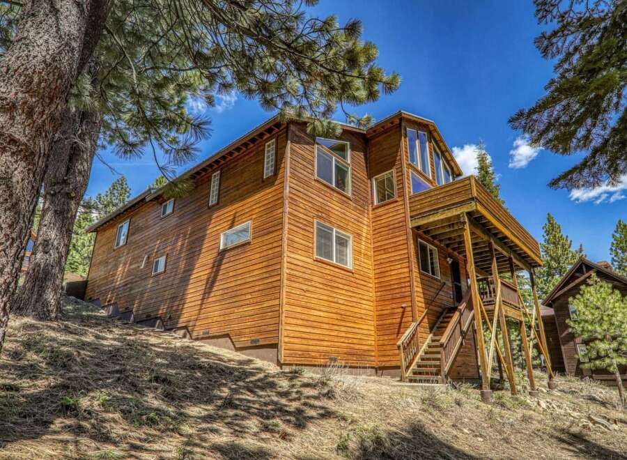 Nestled amongst tall pine trees, this stunning wooden home offers a rustic mountain retreat.