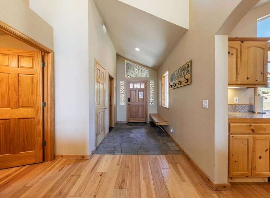 Step into this charming entryway featuring warm hardwood floors and a vaulted ceiling that creates an airy atmosphere.