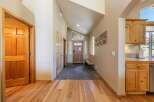 Step into this charming entryway featuring warm hardwood floors and a vaulted ceiling that creates an airy atmosphere.