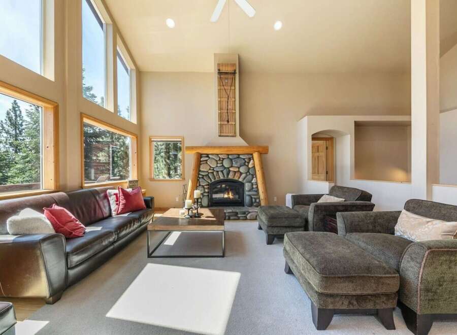 Experience luxurious living in this spacious great room, featuring a stunning floor-to-ceiling stone fireplace and expansive windows that flood the space with natural light.
