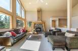 Experience luxurious living in this spacious great room, featuring a stunning floor-to-ceiling stone fireplace and expansive windows that flood the space with natural light.