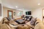 Experience ultimate relaxation in this spacious living room, featuring a large, plush sectional sofa perfect for gathering with loved ones.