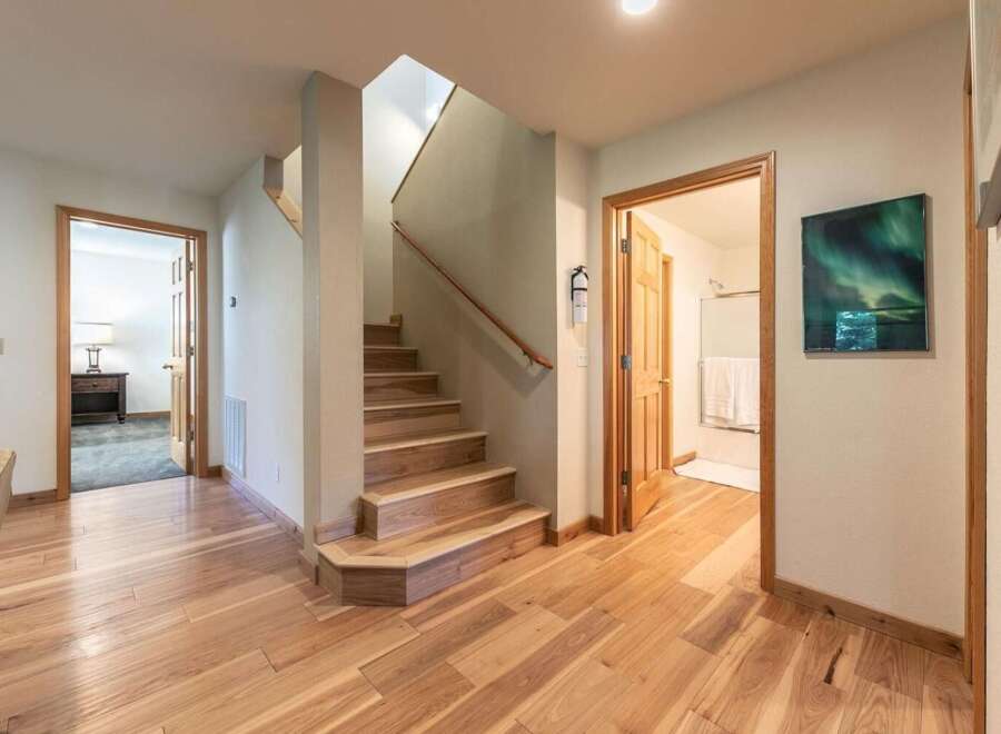 Step into this inviting hallway featuring beautiful hardwood floors that lead to a charming staircase.
