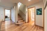 Step into this inviting hallway featuring beautiful hardwood floors that lead to a charming staircase.