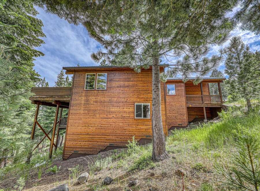 Nestled amidst tall pine trees, this charming wooden home offers a serene mountain retreat.