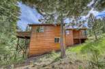 Nestled amidst tall pine trees, this charming wooden home offers a serene mountain retreat.