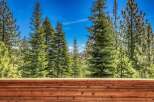 Experience breathtaking mountain views from this stunning property, surrounded by lush evergreen trees.