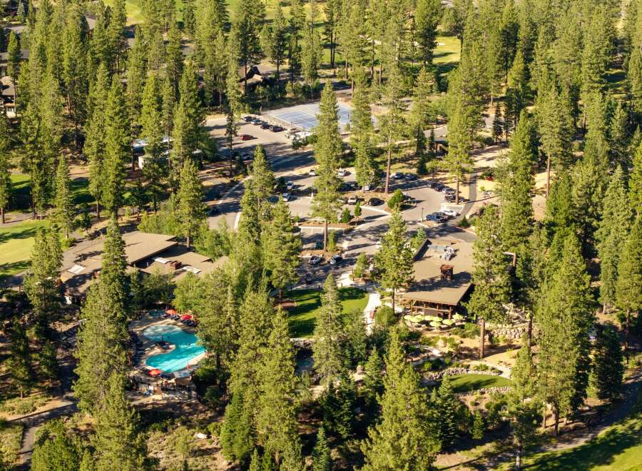 Experience luxury living surrounded by nature with this stunning property featuring a resort-style pool and a charming outdoor dining area.