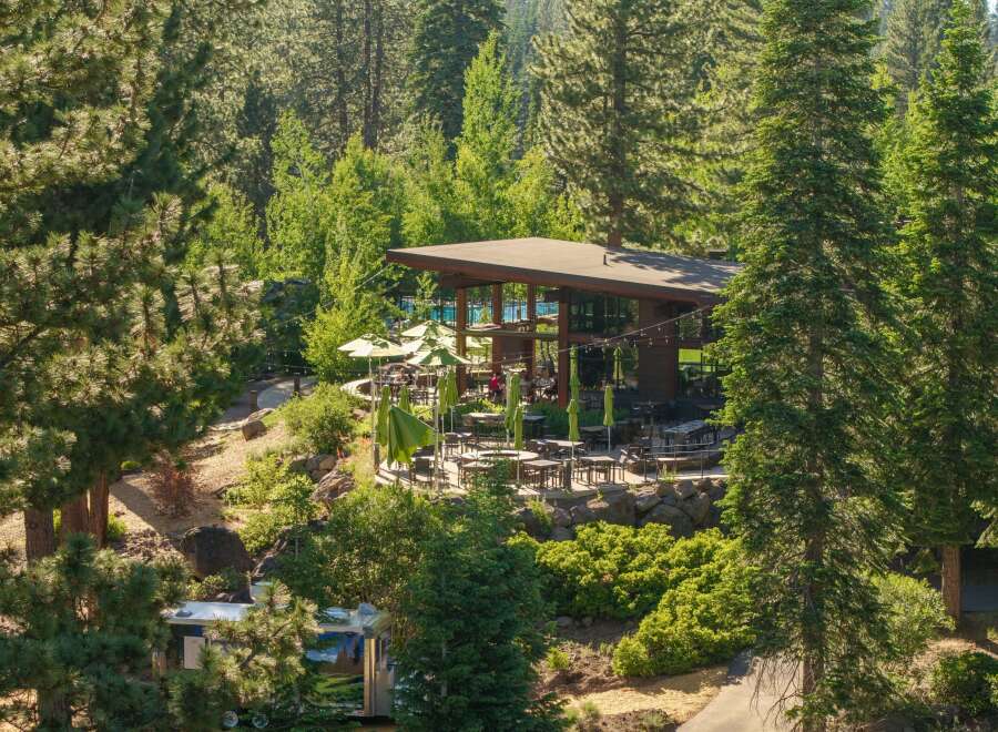 Experience outdoor dining at its finest with this stunning property featuring a spacious patio area surrounded by lush greenery and mature trees.