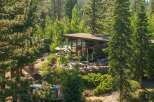 Experience outdoor dining at its finest with this stunning property featuring a spacious patio area surrounded by lush greenery and mature trees.