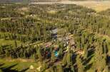 Experience luxury living amidst a stunning pine forest setting with this aerial view of a resort-style property.