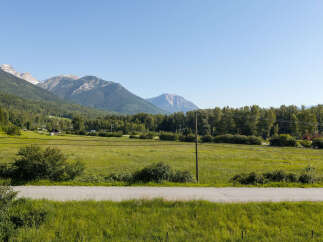 Experience the serene beauty of this property, nestled amidst rolling green fields and majestic mountains.