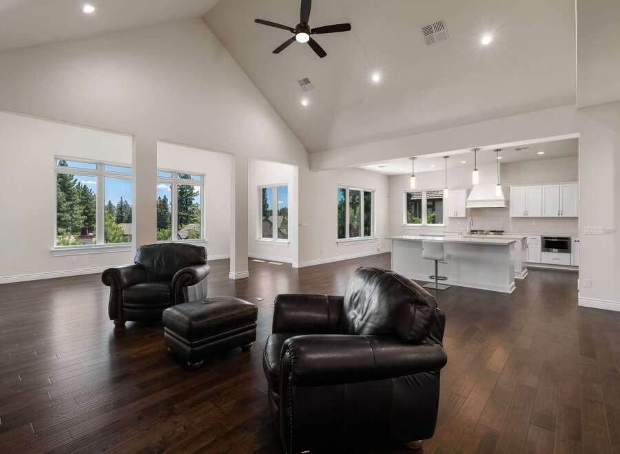 Experience luxury living in this stunning open-concept home featuring a grand vaulted ceiling with a modern fan and recessed lighting.