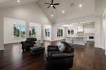 Experience luxury living in this stunning open-concept home featuring a grand vaulted ceiling with a modern fan and recessed lighting.