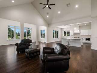 Experience luxury living in this stunning open-concept home featuring a grand vaulted ceiling with a modern fan and recessed lighting.