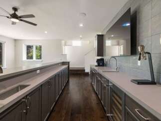 This modern home features a sleek wet bar area perfect for entertaining, complete with a wine fridge and ample cabinet space.