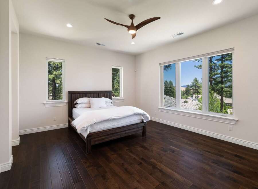 Experience breathtaking mountain views from this serene bedroom, featuring a spacious king-size bed with crisp white linens.