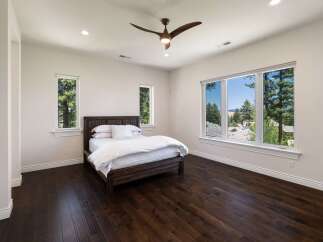 Experience breathtaking mountain views from this serene bedroom, featuring a spacious king-size bed with crisp white linens.
