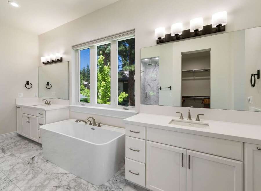 Indulge in luxury in this stunning master bathroom, featuring a freestanding soaking tub perfect for relaxation.