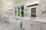 Indulge in luxury in this stunning master bathroom, featuring a freestanding soaking tub perfect for relaxation.