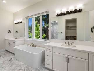 Indulge in luxury in this stunning master bathroom, featuring a freestanding soaking tub perfect for relaxation.