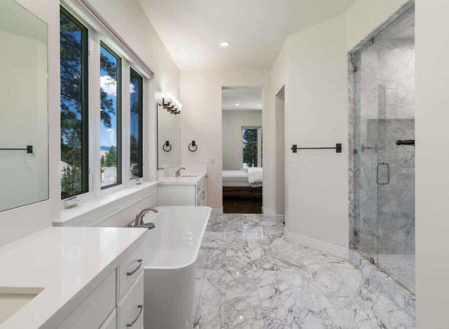 Experience luxury in this stunning bathroom featuring a freestanding soaking tub and a spacious marble shower.