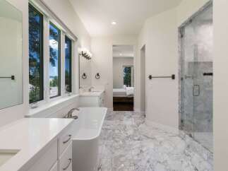 Experience luxury in this stunning bathroom featuring a freestanding soaking tub and a spacious marble shower.