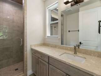 Experience modern luxury in this stunning bathroom, featuring a spacious walk-in shower with elegant tile work and a sleek glass enclosure.